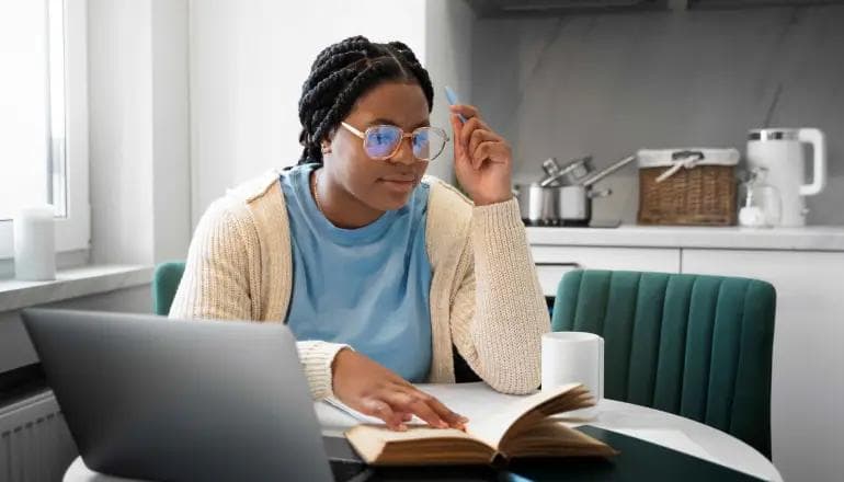 Person learning web design on a laptop with website layouts on the screen